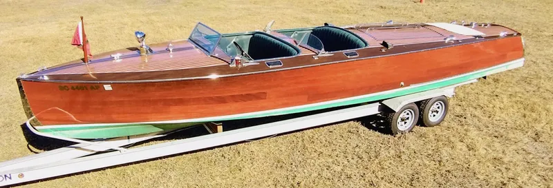 The Image of 1988 Hacker-Craft 30 Triple Cockpit boat on trailer, showcasing classic wooden design. - 0