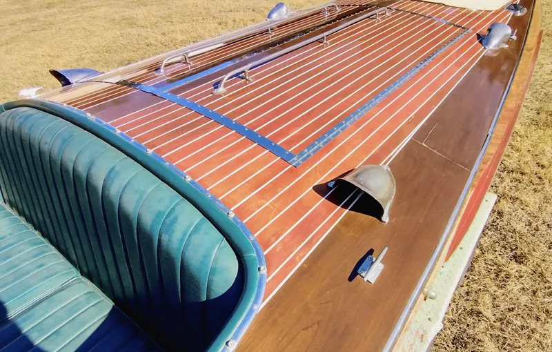 Slide: The Image of 1988 Hacker-Craft 30 Triple Cockpit boat with polished wood finish and green seating. - 13