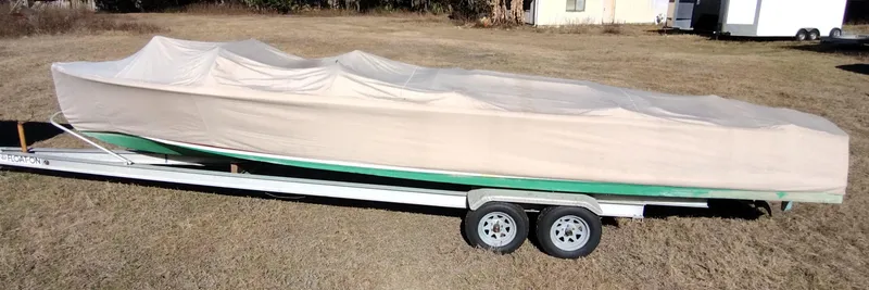 Slide: The Image of Covered 1988 Hacker-Craft 30 Triple Cockpit boat on trailer in grassy area. - 19