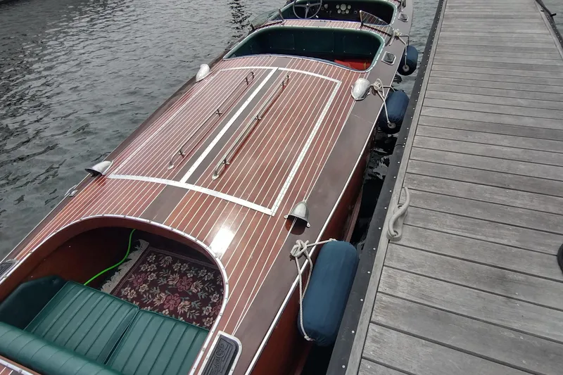 Slide: The Image of 1988 Hacker-Craft 30 Triple Cockpit boat docked, showcasing elegant wooden design and classic style. - 22