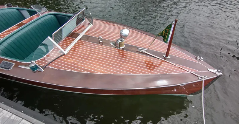 Slide: The Image of 1988 Hacker-Craft 30 Triple Cockpit boat with polished wood finish on calm water. - 24