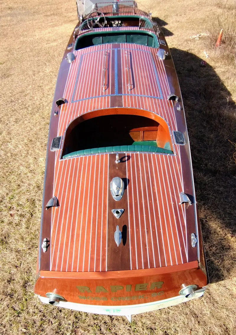 Slide: The Image of 1988 Hacker-Craft 30 Triple Cockpit boat with polished wood finish on grass. - 3