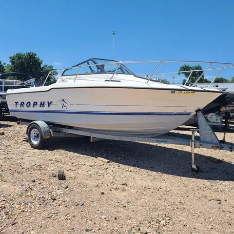 Slide: The Image of 1993 Bayliner Trophy boat on a trailer in a gravel lot. - 2