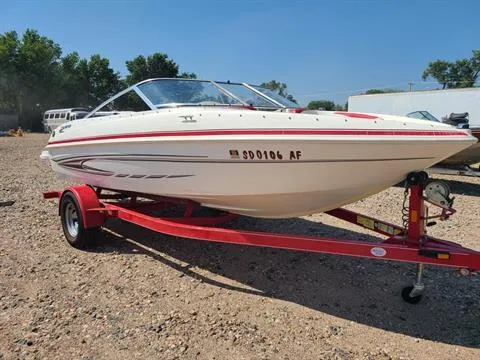 Slide: The Image of 2010 Glastron MX 185 boat on a red trailer in a gravel lot. - 5