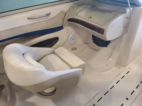Slide: The Image of 2004 Glastron GX 235 boat interior with white seating and dashboard. - 2