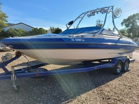 Slide: The Image of 2004 Glastron GX 235 boat on a trailer in a sunny outdoor setting. - 9