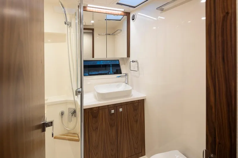 Slide: The Image of Luxurious bathroom in 2024 Riviera 46 Sports Motor Yacht with modern fixtures and wooden cabinetry. - 12