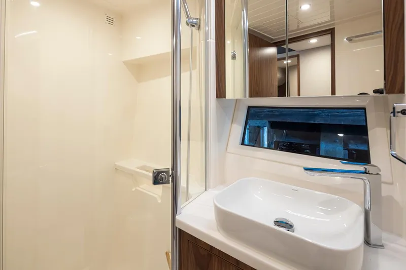 Slide: The Image of Modern bathroom in 2024 Riviera 46 Sports Motor Yacht with sink, mirror, and shower. - 13