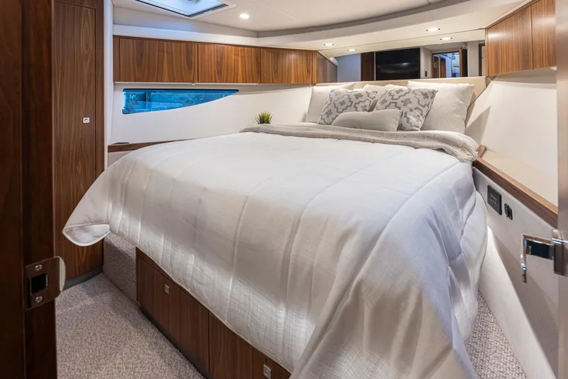 Slide: The Image of Luxurious bedroom in 2024 Riviera 46 Sports Motor Yacht with elegant wood finishes. - 14