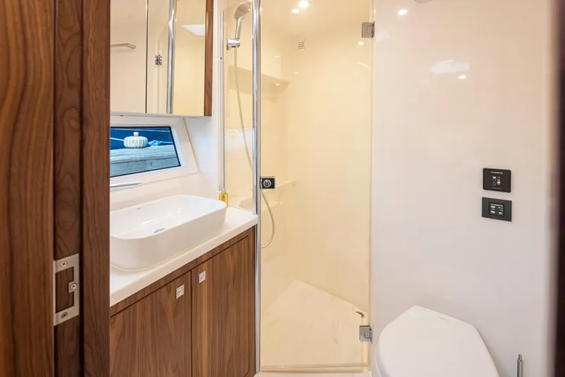 Slide: The Image of Luxurious bathroom in 2024 Riviera 46 Sports Motor Yacht with modern fixtures and wooden cabinetry. - 15
