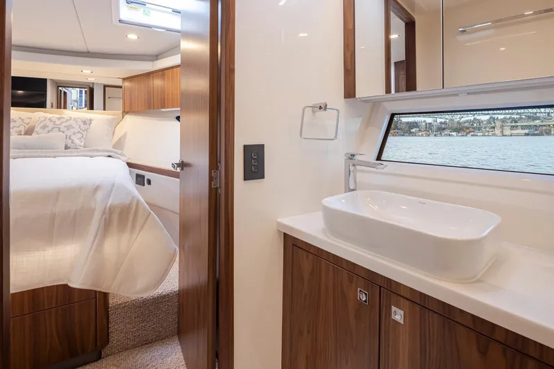 Slide: The Image of Interior of 2024 Riviera 46 Sports Motor Yacht, featuring bedroom and bathroom with modern amenities. - 16