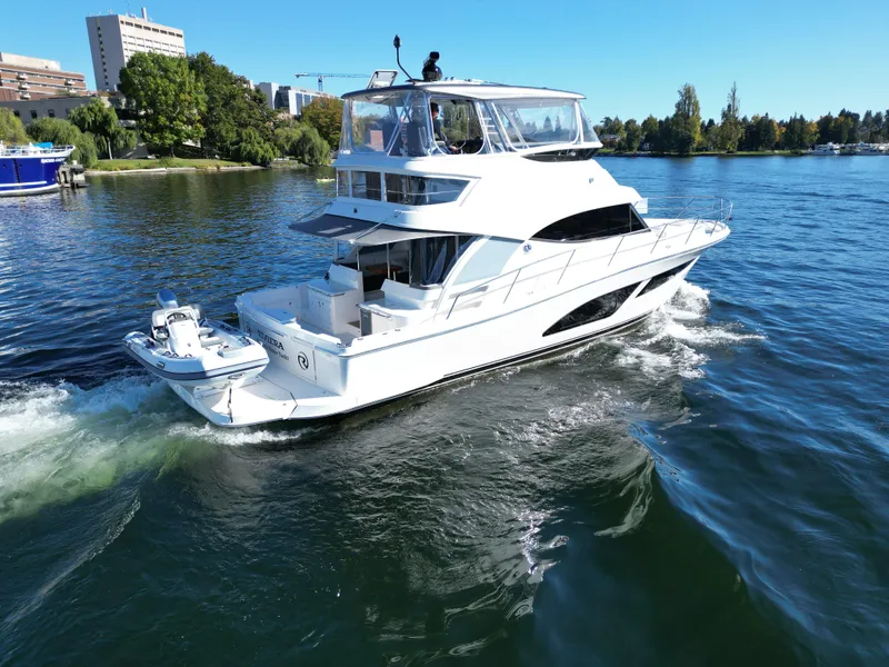 Slide: The Image of 2024 Riviera 46 Sports Motor Yacht cruising on a scenic lake. - 2