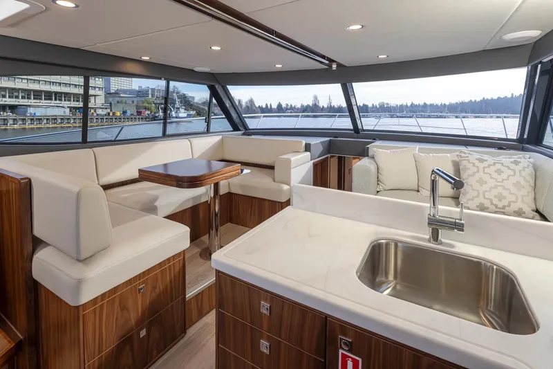 Slide: The Image of Interior of 2024 Riviera 46 Sports Motor Yacht with modern seating and kitchen area. - 21