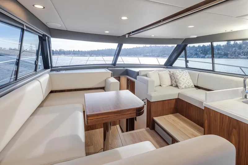 Slide: The Image of Interior of 2024 Riviera 46 Sports Motor Yacht with modern seating and panoramic windows. - 22