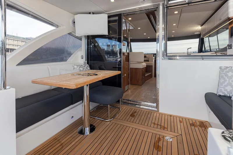 Slide: The Image of Interior of 2024 Riviera 46 Sports Motor Yacht with teak flooring and modern seating. - 32