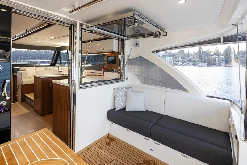 Slide: The Image of 2024 Riviera 46 Sports Motor Yacht interior with seating and water view. - 33