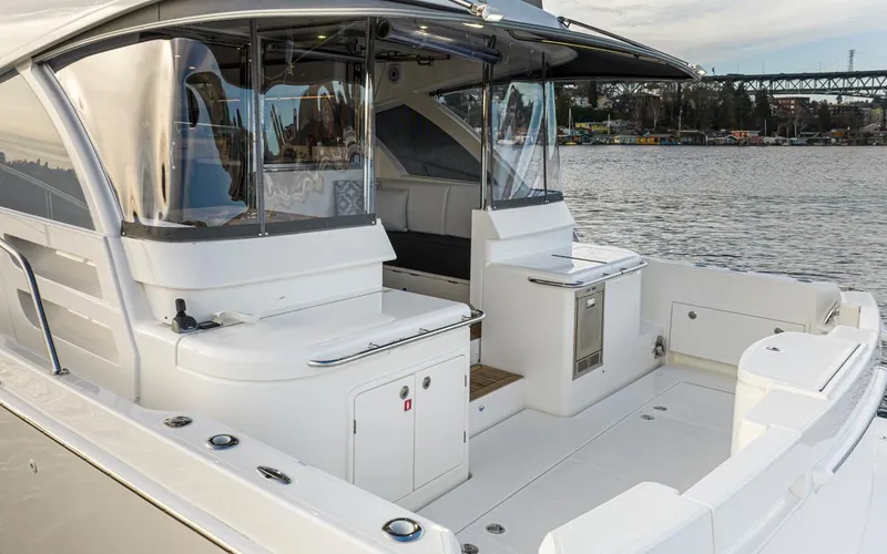 Slide: The Image of 2024 Riviera 46 Sports Motor Yacht, spacious deck with modern amenities, docked by the water. - 35