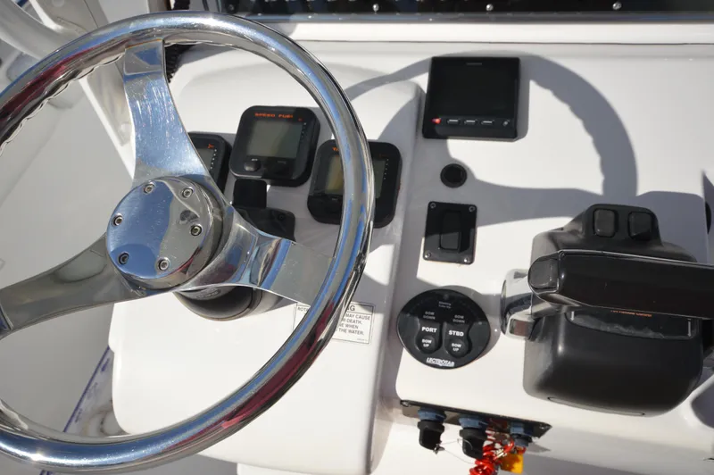 Slide: The Image of 2015 Sportsman 25 Center Console boat dashboard with steering wheel and controls. - 21
