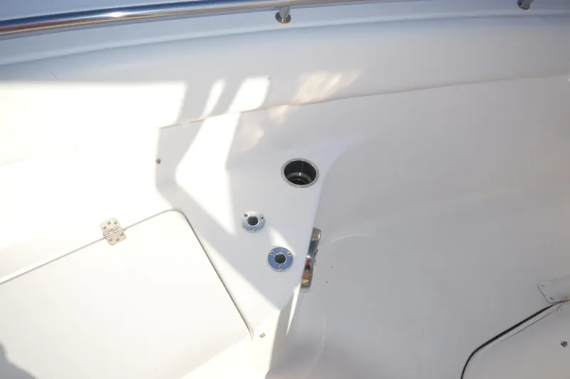 Slide: The Image of 2015 Sportsman 25 Center Console boat interior detail with storage compartment and cup holders. - 32