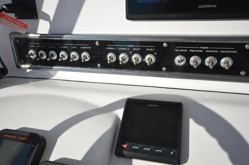 Slide: The Image of Control panel of a 2015 Sportsman 25 Center Console boat with various switches and Garmin display. - 36