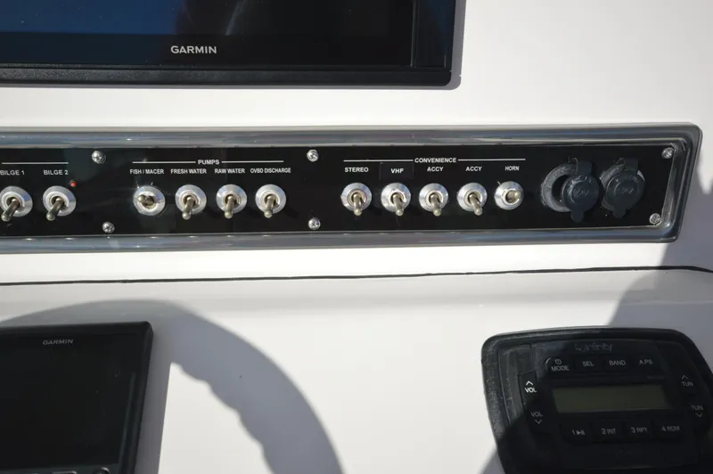 Slide: The Image of Control panel of a 2015 Sportsman 25 Center Console boat with various switches and Garmin display. - 37