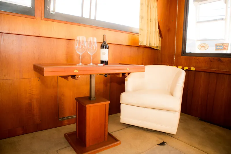 Slide: The Image of Interior of 1986 Viking 41 yacht with wine bottle, glasses, and white chair. - 10