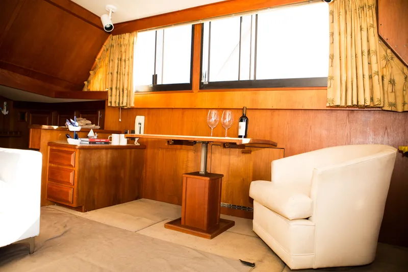 Slide: The Image of Interior of 1986 Viking 41 yacht with wooden cabinetry, wine bottle, and white armchair. - 11