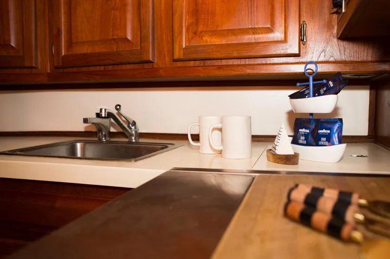 Slide: The Image of 1986 Viking 41 kitchen with wooden cabinets, sink, coffee mugs, and Lavazza espresso packets. - 14