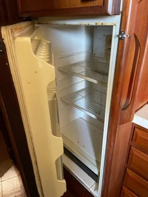Slide: The Image of Open 1986 Viking 41 refrigerator with empty shelves in a wooden kitchen cabinet. - 18