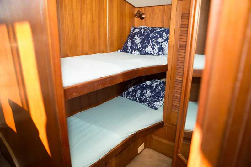 Slide: The Image of 1986 Viking 41 yacht interior with wooden bunk beds and floral pillows. - 20