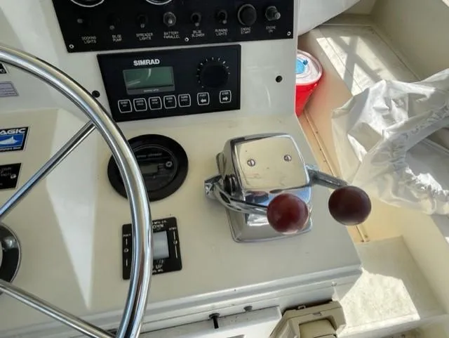 Slide: The Image of Control panel of a 1986 Viking 41 boat with steering wheel and throttle. - 27