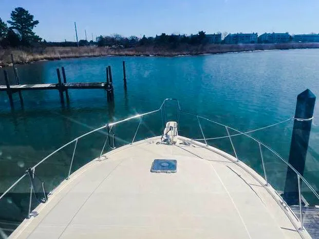 Slide: The Image of Bow view of 1986 Viking 41 yacht docked in a serene marina. - 3