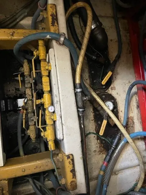 Slide: The Image of Engine compartment of a 1986 Viking 41 boat with hoses and mechanical components. - 36