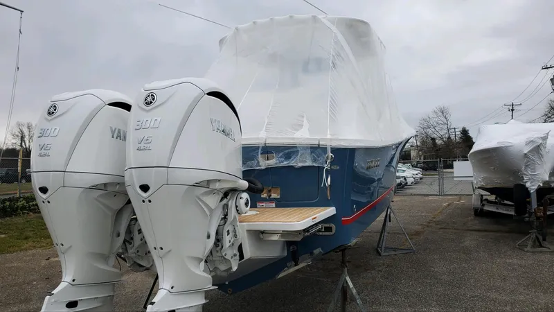 Slide: The Image of 2023 Regulator 28 boat with twin Yamaha engines, covered and on display outdoors. - 11