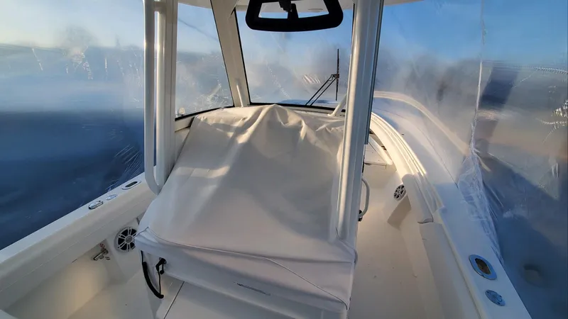 Slide: The Image of 2023 Regulator 28 boat interior with covered console and clear enclosure. - 15