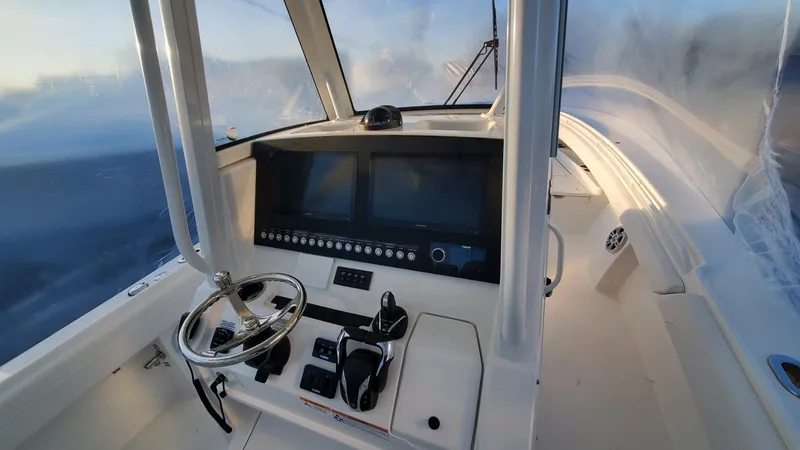 Slide: The Image of 2023 Regulator 28 boat cockpit with modern steering and navigation system. - 2