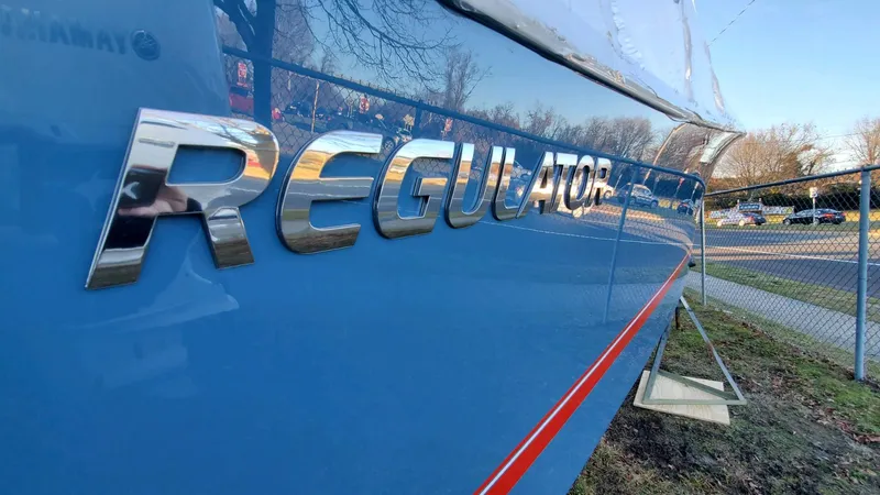 Slide: The Image of 2023 Regulator 28 boat with chrome logo on blue hull. - 22