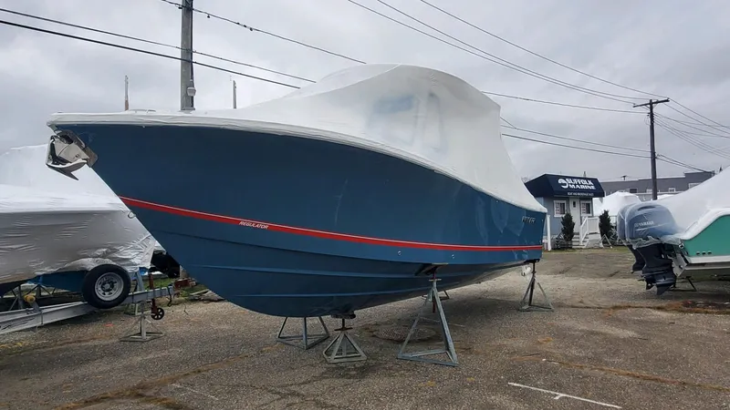 Slide: The Image of 2023 Regulator 28 boat covered and elevated on stands in a parking lot. - 3