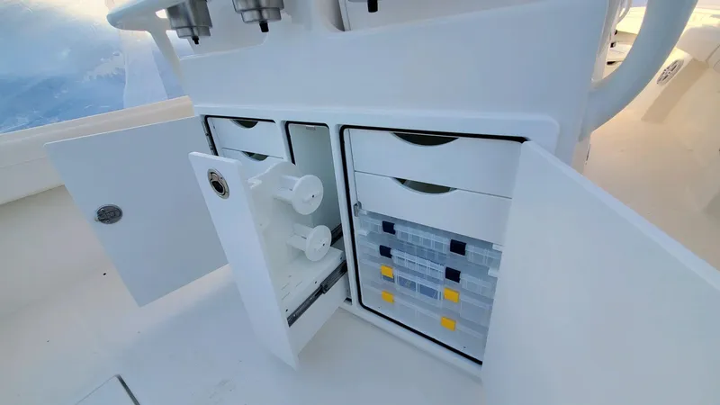 Slide: The Image of 2023 Regulator 28 boat storage compartments with open doors, showcasing organized interior. - 4