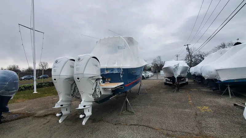 Slide: The Image of 2023 Regulator 28 boat with twin engines, covered and parked outdoors. - 7