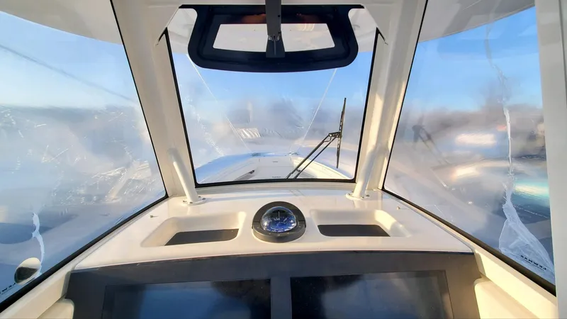 Slide: The Image of 2023 Regulator 28 boat cockpit view with clear windshield and dashboard instruments. - 8