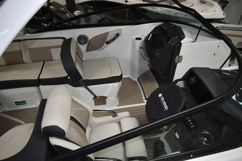 Slide: The Image of 2023 Monterey M6 boat interior with beige and black seating, modern dashboard, and steering wheel. - 10