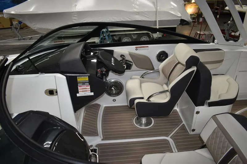 Slide: The Image of 2023 Monterey M6 boat interior with beige and black seating, modern dashboard, and wood-patterned flooring. - 17