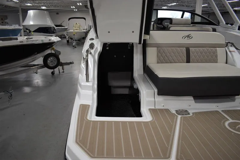Slide: The Image of 2023 Monterey M6 boat interior with open storage compartment and cushioned seating. - 22