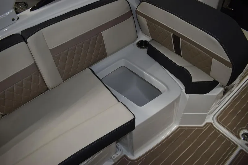 Slide: The Image of 2023 Monterey M6 boat interior with beige and black cushioned seating and built-in storage. - 33