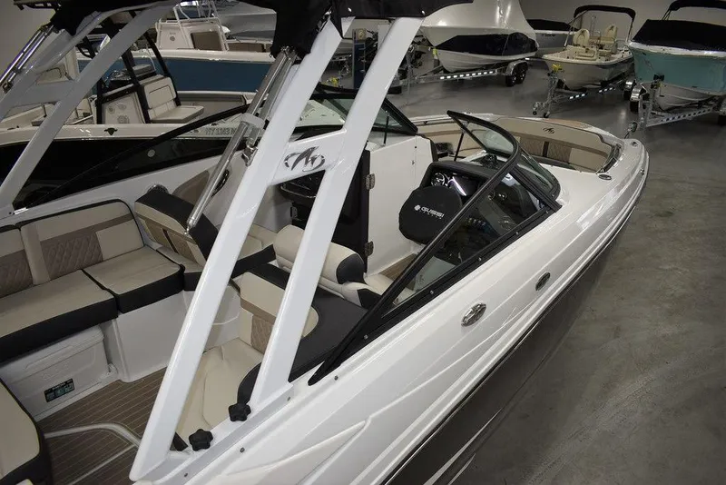 Slide: The Image of 2023 Monterey M6 boat interior with seating and helm, displayed in a showroom. - 9