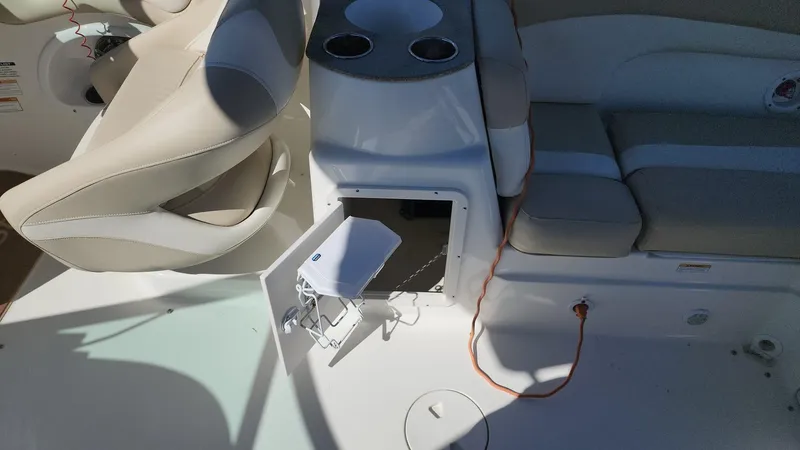 Slide: The Image of 2017 NauticStar 243DC Sport Deck interior with open storage compartment and seating. - 10