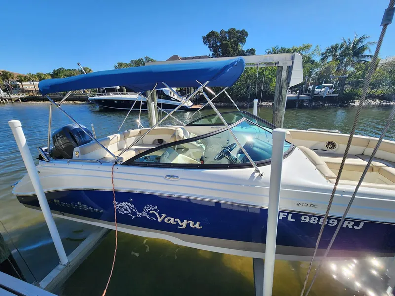 Slide: The Image of 2017 NauticStar 243DC Sport Deck boat docked with blue canopy. - 13