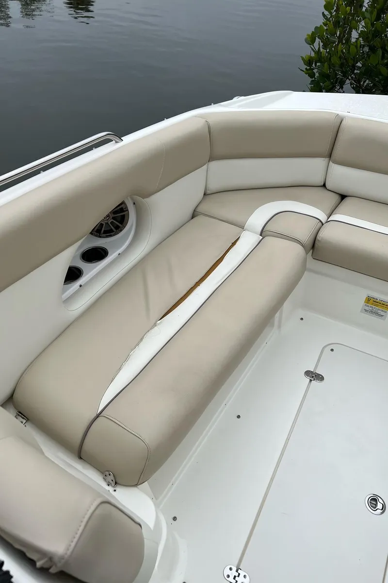 Slide: The Image of 2017 NauticStar 243DC Sport Deck boat with beige seating and white accents. - 16