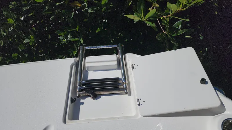 Slide: The Image of 2017 NauticStar 243DC Sport Deck boat with a folded swim ladder. - 27